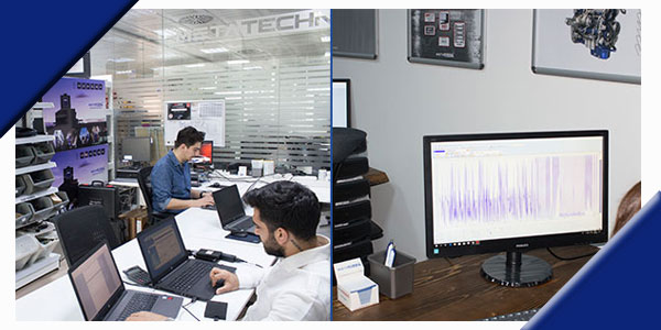 Office setting with multiple employees working on laptops, focusing on data analysis displayed on a computer monitor.