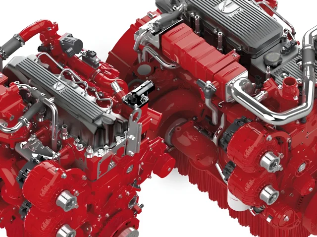 Close-up of two red, intricate, industrial engine systems with various metallic pipes and components. The engines feature multiple cylindrical and geometric shapes, showcasing complex engineering. Set against a white background. Engine control unit programming